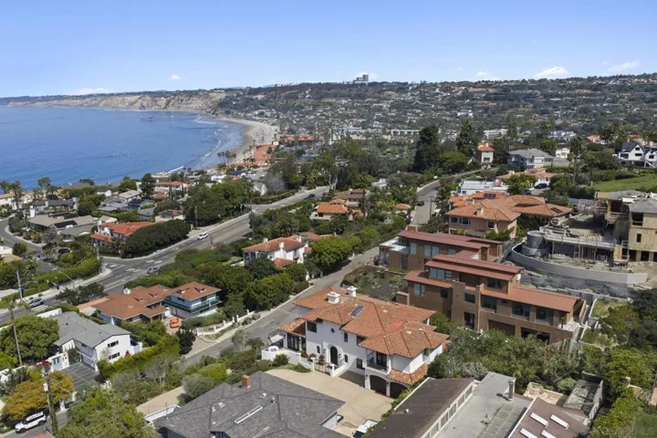 Aerial view of La Jolla’s sweeping coastline, where rolling hills, coastal homes, and the curve of the shoreline create a picturesque setting defined by ocean views and relaxed seaside living.