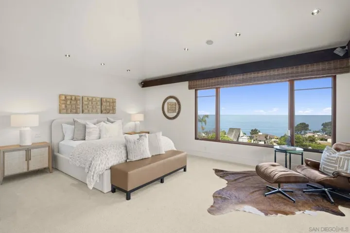 Large primary bedroom with vaulted ceilings, abundant natural light, and panoramic ocean views, creating a serene retreat where sky and sea become part of everyday living.