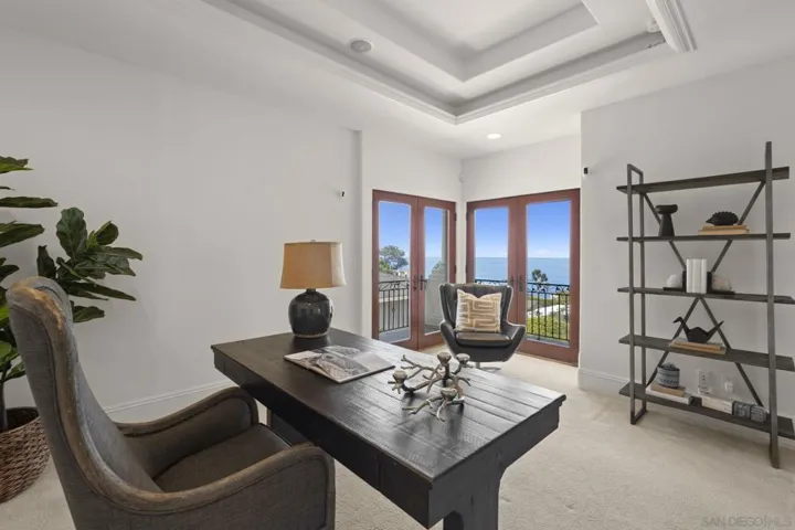 Office or optional third bedroom with crown molding and soft cove lighting, where two sets of French doors open to a balcony, inviting in natural light and a seamless indoor outdoor flow.