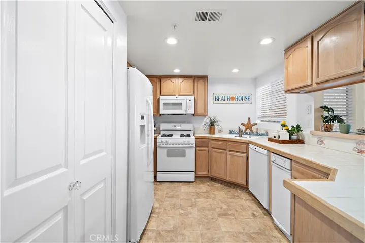 Kitchen with gas burners, dishwasher, trash compactor, refridgerator.