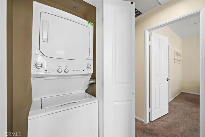 Hall way has stackable washer and dryer, included in sale.