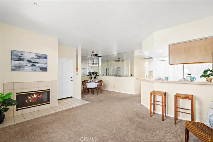 Living room has a cozy gas fireplace. Dining area with mirrored half wall, ceiling fan.