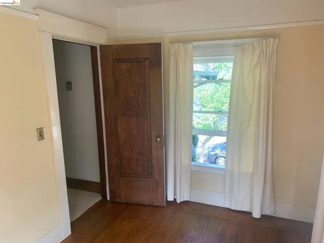 Unfurnished room featuring dark wood-type flooring and baseboards