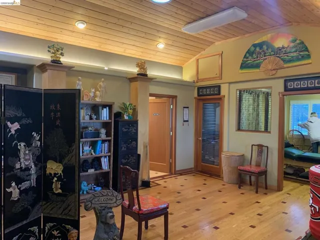 Living room with a vaulted wooden ceiling and light wood-style flooring