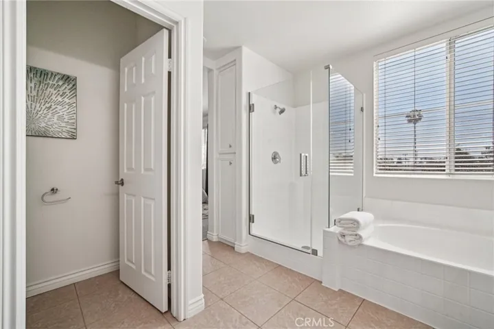 Primary bathroom with duel sinks, separate shower with frameless door and tub, water closet.