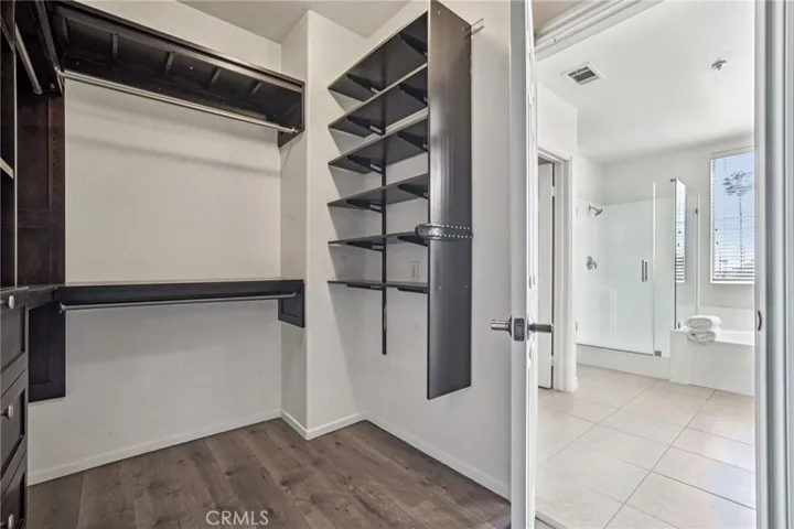 Large fitted  primary closet with shelfing and drawers