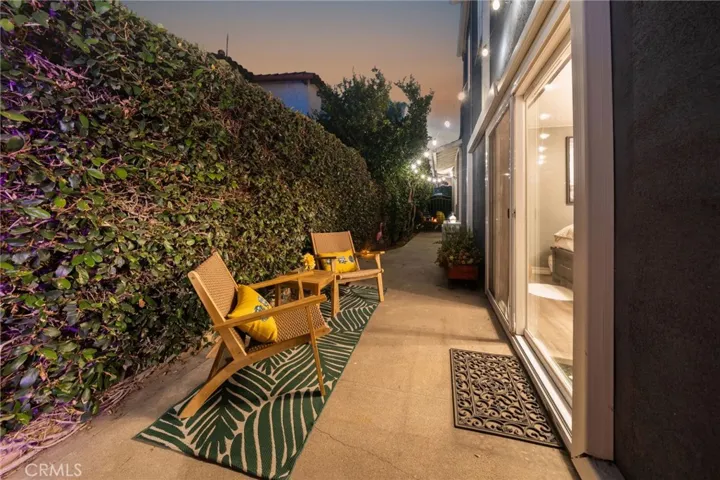 Side yard patio off lower primary with fruit trees.