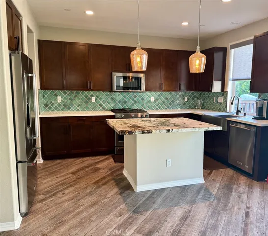 The kitchen also overlooks the backyard through the bay window by the farmhouse stainless steel sink.
