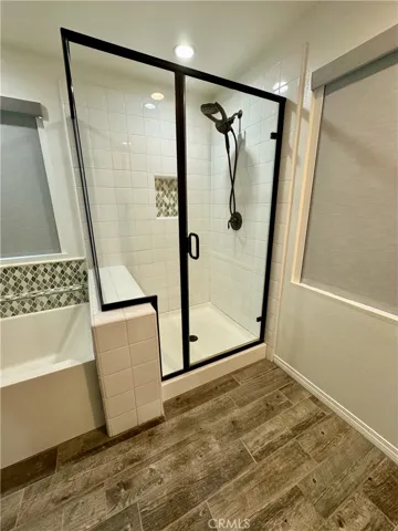 Separate shower surrounded in glass enclosure with oil rubbed bronze.  Relax with these new dual shower head system featuring rain shower head and magnetic hand shower.  Invigorating showers await!