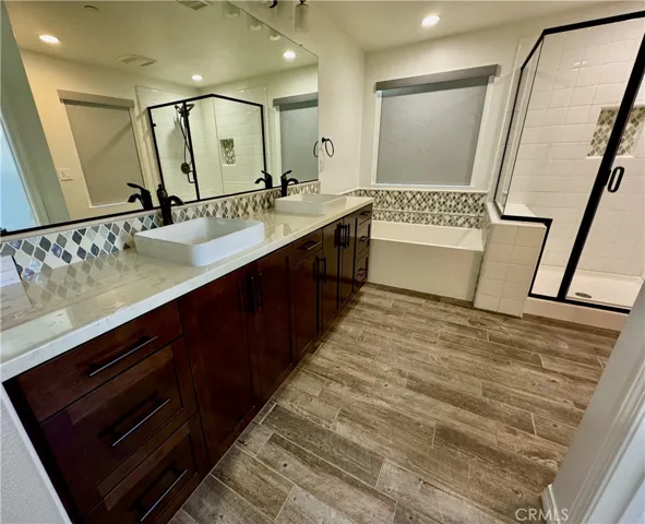 The Primary Bedroom suite features two sinks, a soaking tub, and a separate shower.  Welcome to minimalist resort living (room service not included).