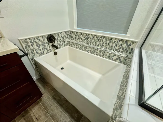 Unwind after a long day at work in this soaking tub with lovely glass tiles.