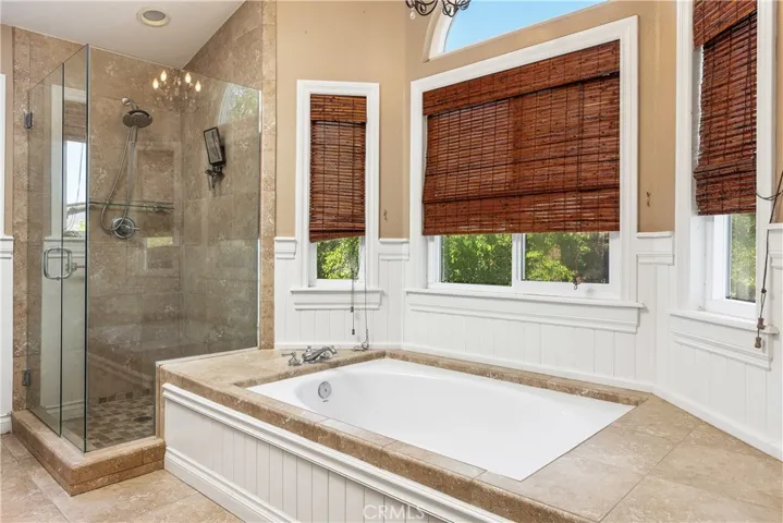 Soaking tub and remodeled shower with frameless glass in primary bath