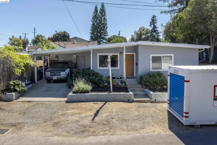 View of front facade with a carport and driveway