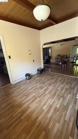 Wood-finish flooring throughout, complemented by a wood plank ceiling with exposed beams
