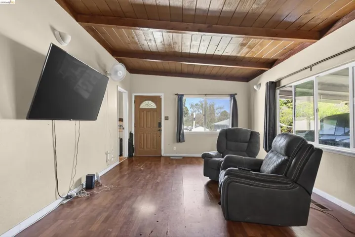 Living room featuring wood finished floors, wooden ceiling, and vaulted ceiling with beams