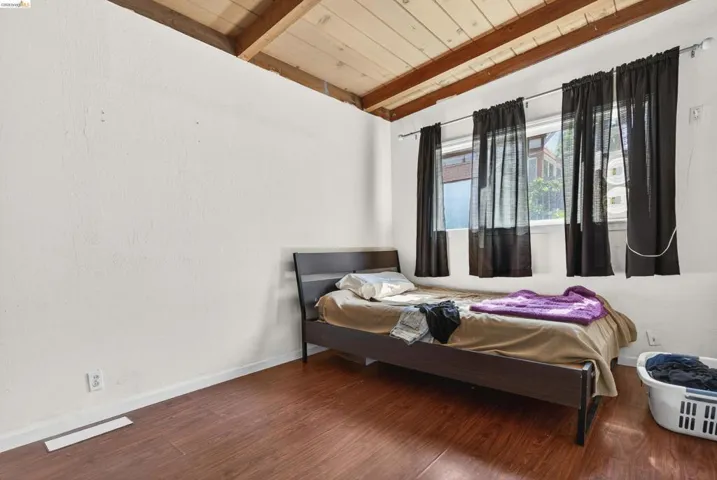 Bedroom featuring wood finished floors and a wood ceiling with exposed beams