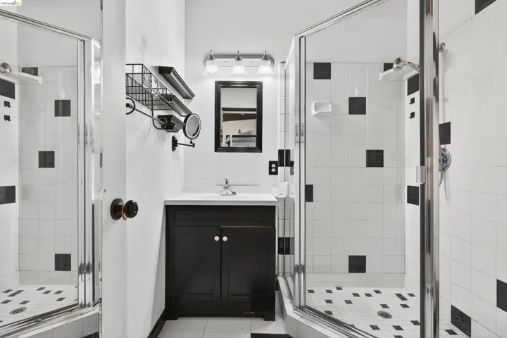 Full bathroom with a stall shower, vanity, and light tile patterned floors