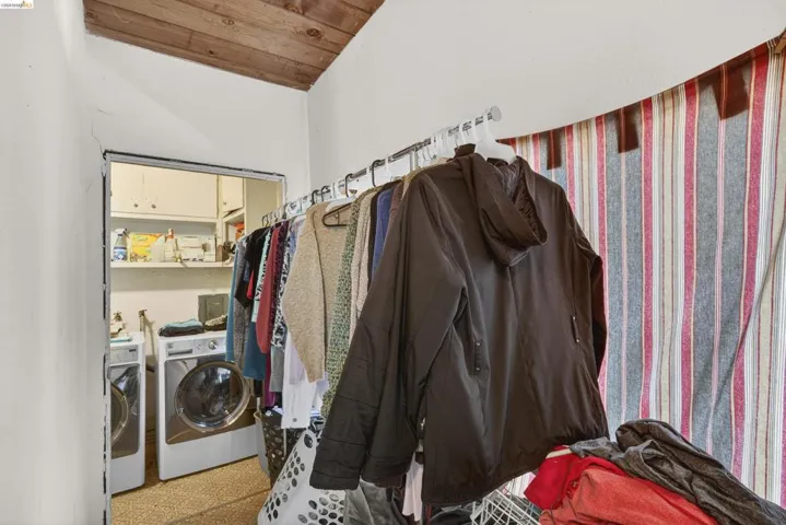Laundry room featuring a vaulted wooden ceiling and independent washer and dryer