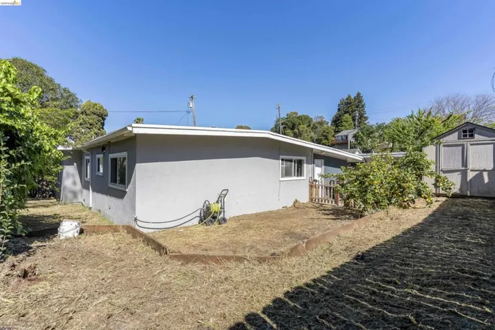 View of home's exterior featuring a shed and stucco siding