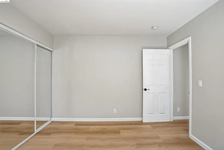 Unfurnished bedroom with light wood-type flooring and a closet