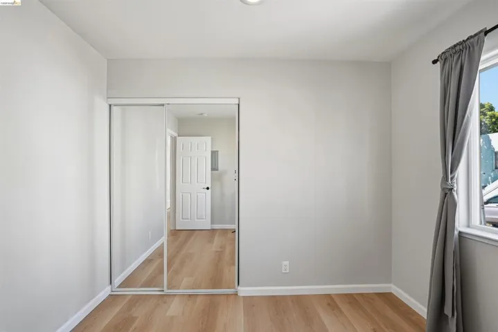 Spare room featuring light wood-style flooring and baseboards