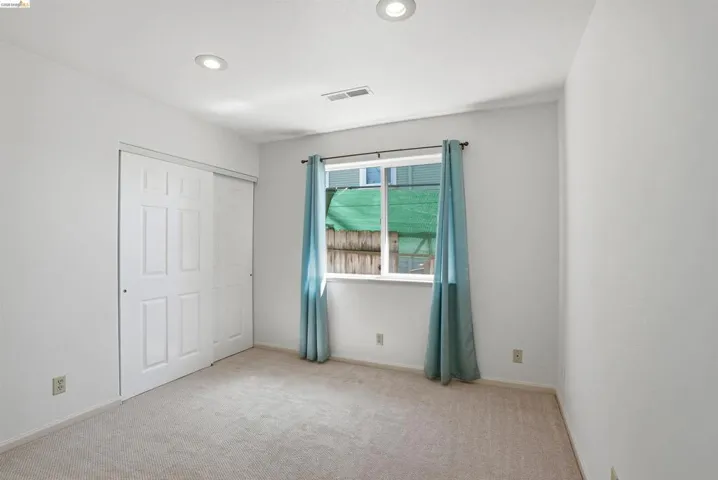 Unfurnished bedroom with light carpet, a closet, and recessed lighting