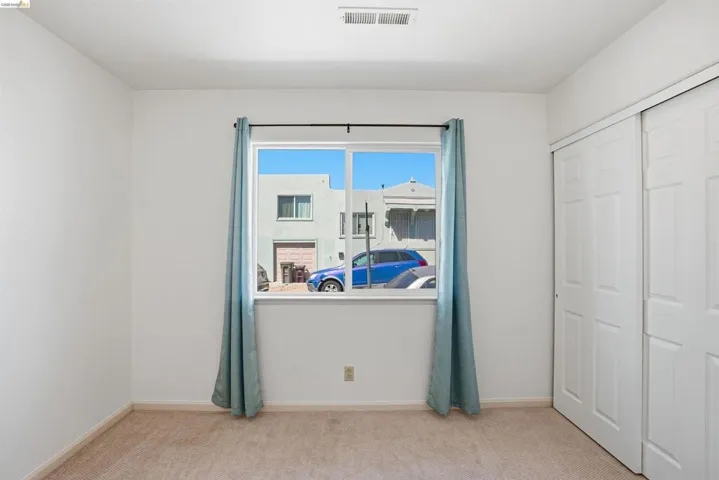 Bedroom featuring light carpet and a closet