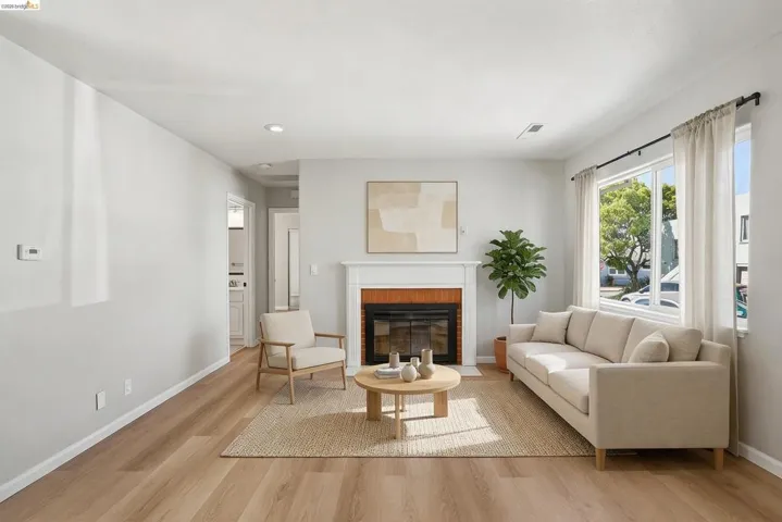Living room with light wood-type flooring, a fireplace, and recessed lighting