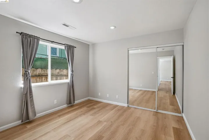 Unfurnished bedroom with light wood-type flooring, a closet, and recessed lighting