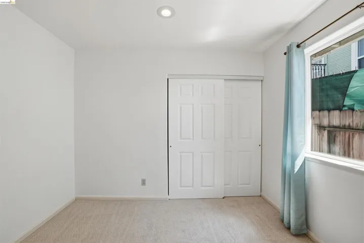 Unfurnished bedroom featuring light carpet and a closet