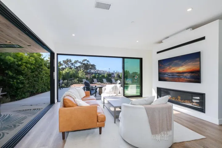 Spacious living room opening up to the back patio & heated pool!