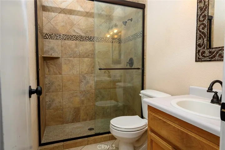 Tiled walk-in shower. Tiled flooring