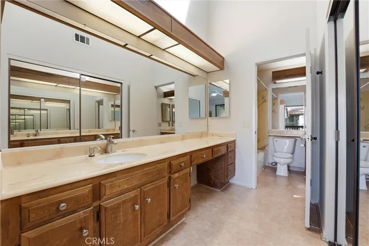 Primary bathroom with generous counter space for everyday ease and comfort as well as shower in tub setup which shares a door to the hallway.