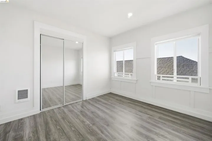 Unfurnished bedroom featuring wood finished floors, a closet, heating unit, and recessed lighting