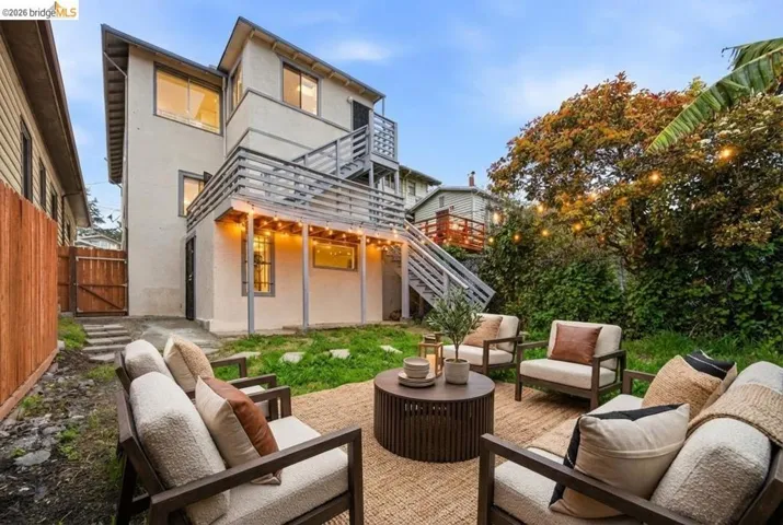 Back of house featuring a patio area, an outdoor lounge area, a gate, stucco siding, and a fenced backyard