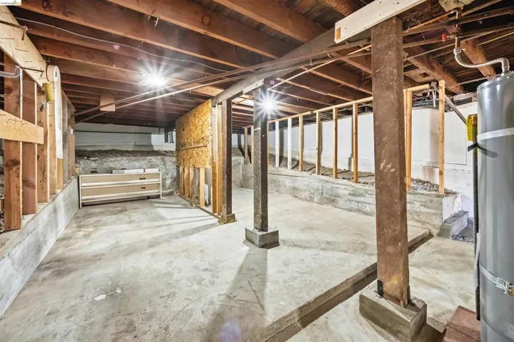 Unfinished below grade area featuring water heater