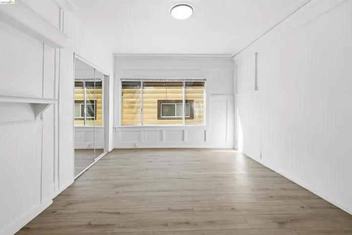 Unfurnished room with a decorative wall, light wood-style flooring, and a fireplace
