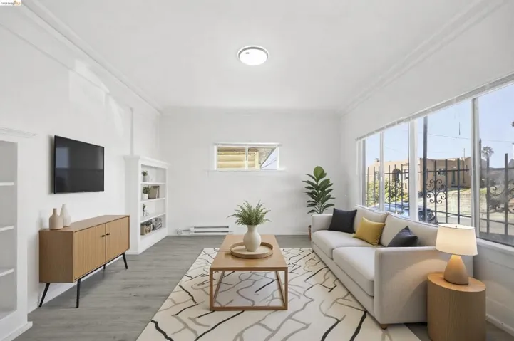 Living room featuring ornamental molding, light wood finished floors, and a baseboard radiator