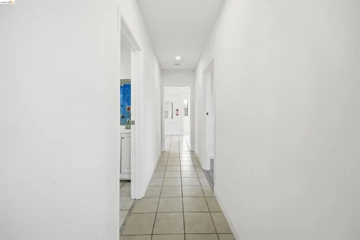 Corridor with light tile patterned floors and recessed lighting