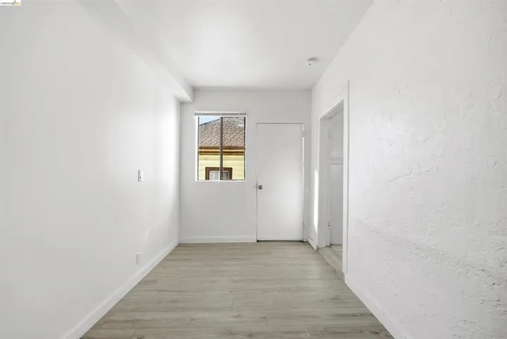 Hallway featuring light wood-type flooring and a textured wall