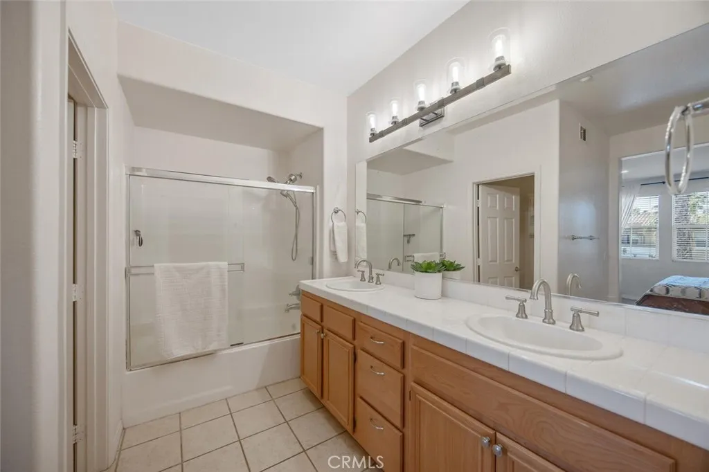 Primary bathroom with dual sinks and stylish lighting