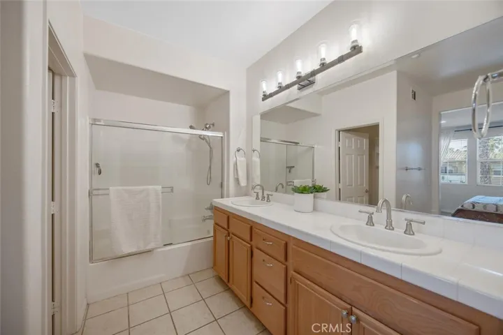 Primary bathroom with dual sinks and stylish lighting