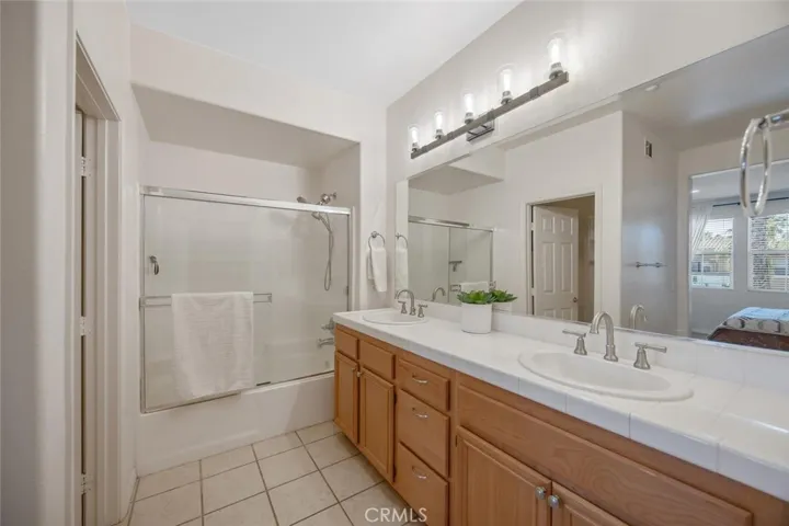 Primary bathroom with dual sinks and stylish lighting