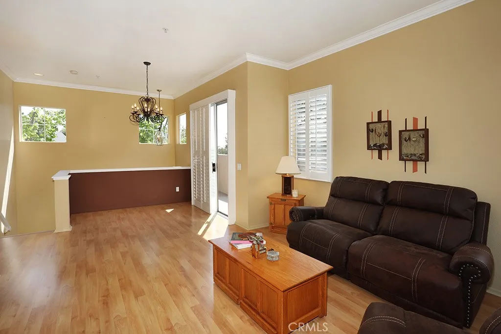 Sunny and bright open floor plan with extra high ceilings, crown moldings, laminate flooring, plantation shutters and designer paints.