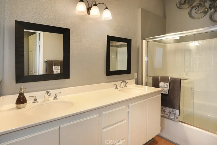 En-suite primary full bath with a double sink vanity, love the ample counter space. The commode is its own space with a door.