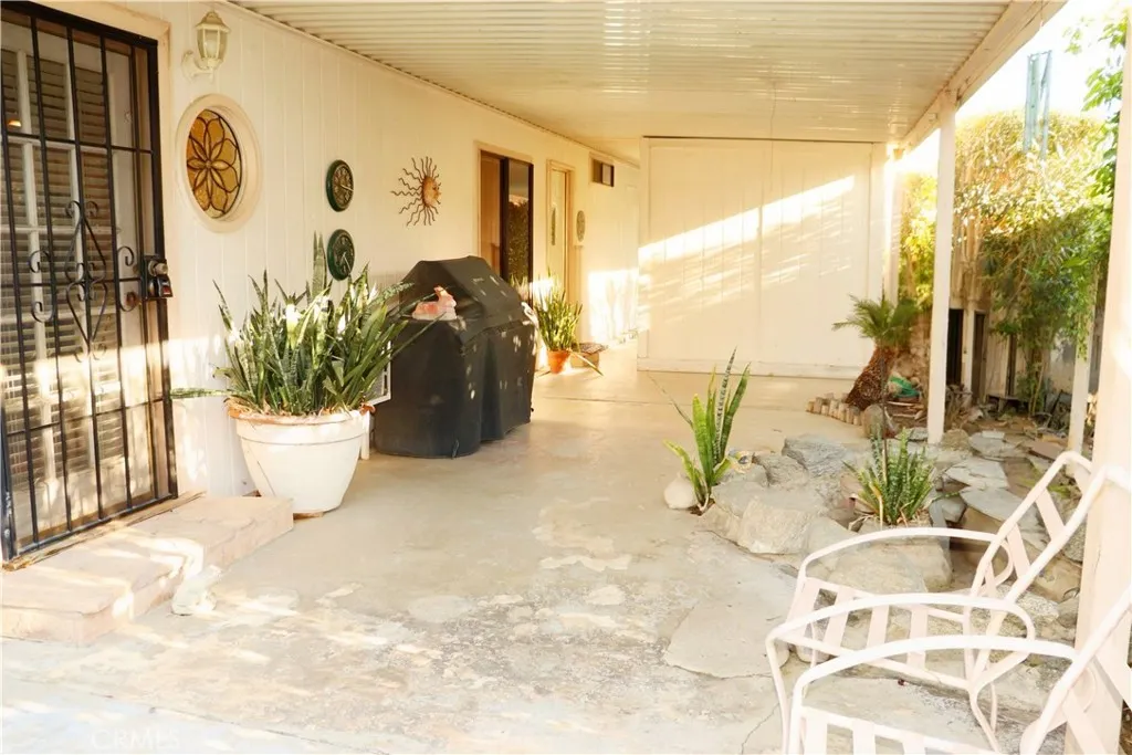 SIDE PATIO WITH BBQ AREA AND SMALL POND AREA BEHIND SHED