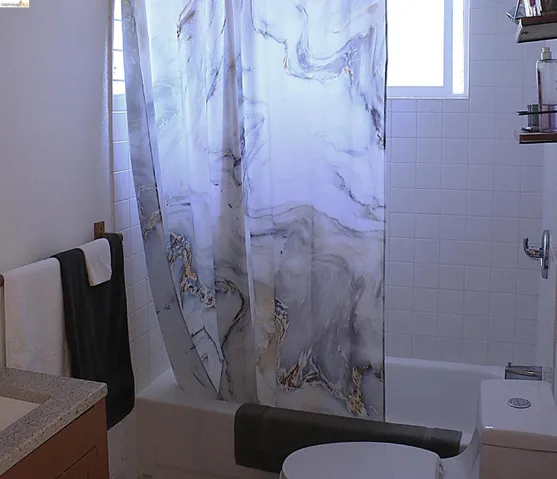 Full bathroom with shower / tub combo and vanity