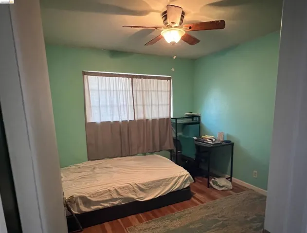 Bedroom with dark wood finished floors and a ceiling fan