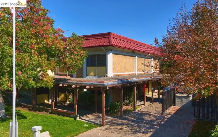Back of house featuring a metal roof, stucco siding, and an outbuilding