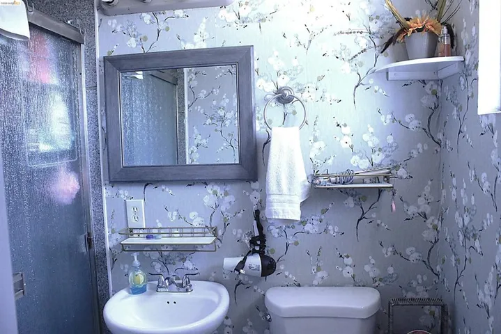 Bathroom with wallpapered walls and toilet